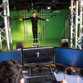 Student in front of a green screen in the GRID lab